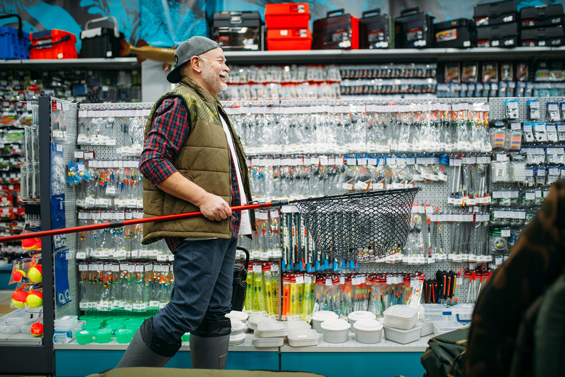 fisherman-with-net-and-toolbox-in-fishing-shop-2024-12-01-01-25-56-utc